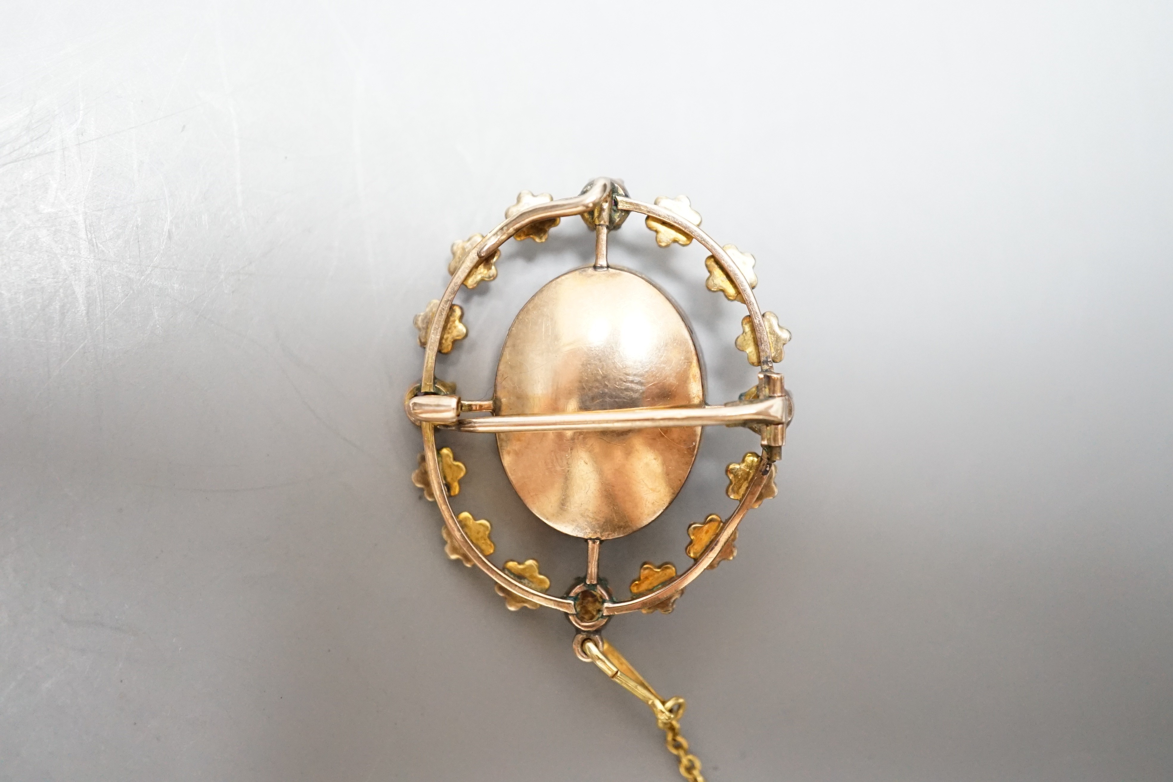 An Edwardian yellow metal, split pearl and ruby mounted oval cameo shell pendant brooch, 32mm, gross weight 6 grams.